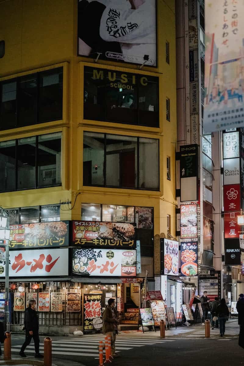 a busy city street at night with people crossing the street