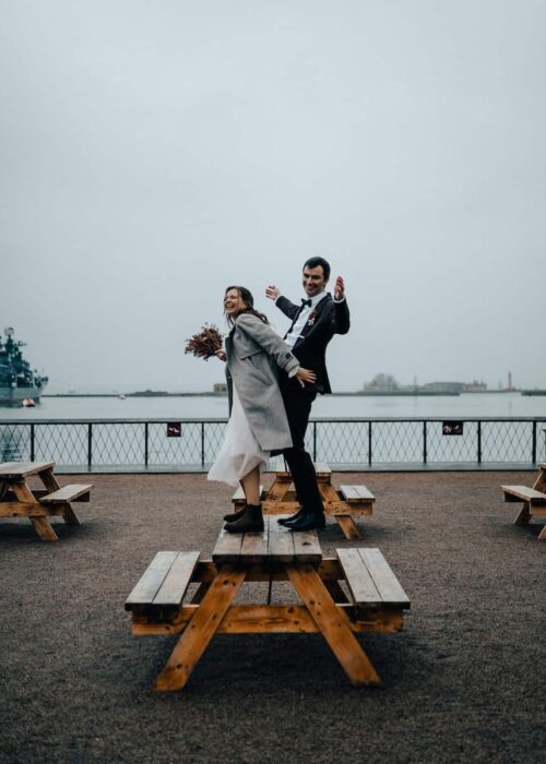 a man and a woman standing on a picnic table